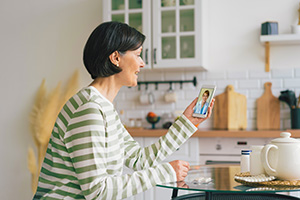 Woman in a striped top talking with a medical professional on video call