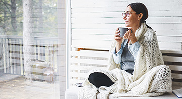 Woman drinking tea looking at window