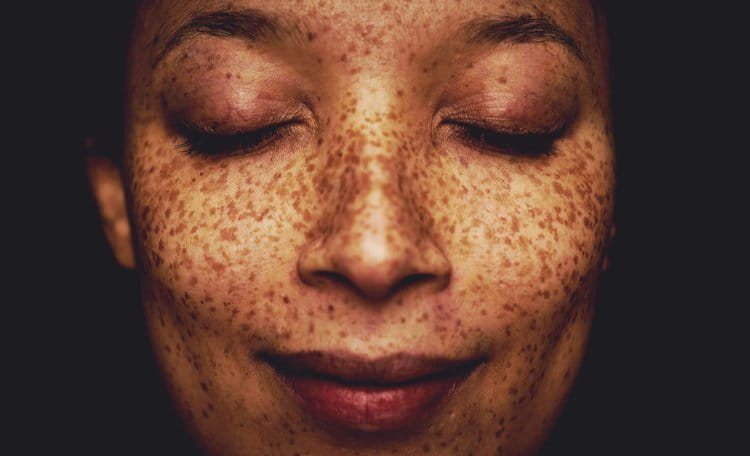 A close up of a woman's face, looking peaceful