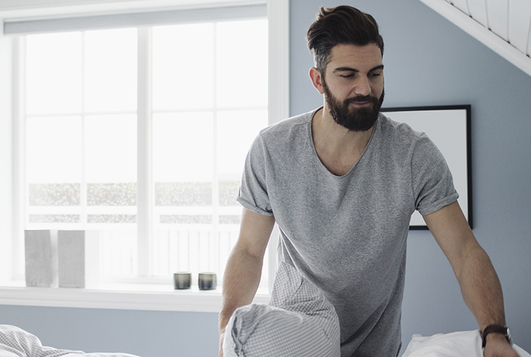 Man looking sleeping getting out of bed.